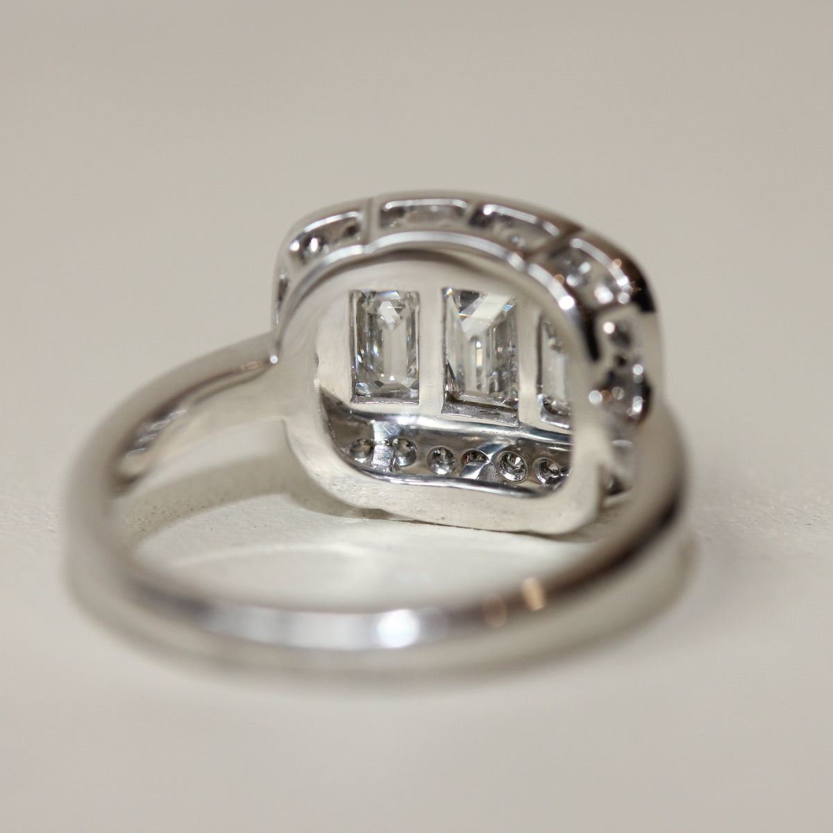18CT WHITE GOLD EMERALD CUT DIAMOND HALO TRILOGY RING